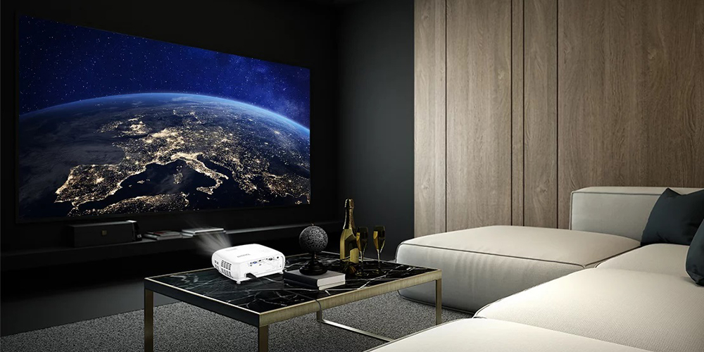 Uma sala de estar moderna, ambiente escuro, um sofá branco confortável, mesa pequena de porcelanato preta com projetor em cima, projetando uma imagem de satélite da terra.